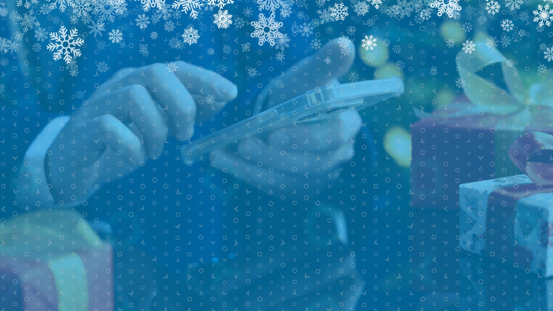 Close up image of hands scrolling on phone next to Christmas presents.