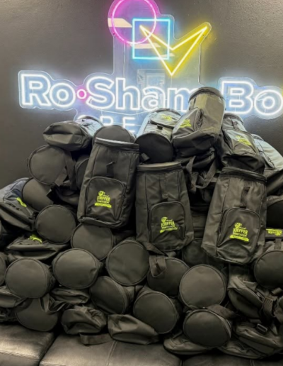 Kieffer Golf Tournament bags packed in front of RoShamBo Creative neon sign